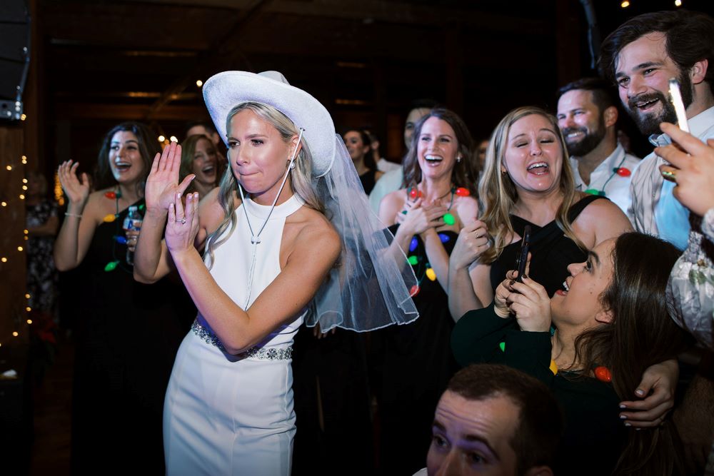 Bride wearing cowgirl hat and dancing with Guests in the Event Hall. 
