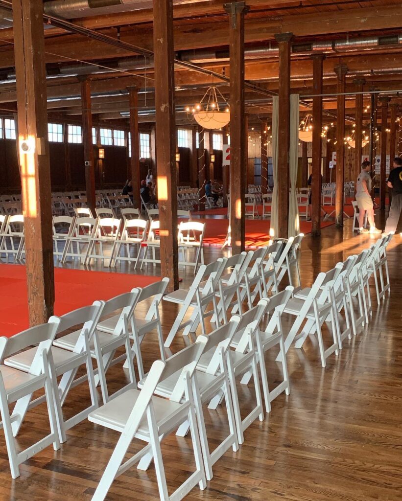 White chairs and large red placements for a karate tournament in the Event Hall.