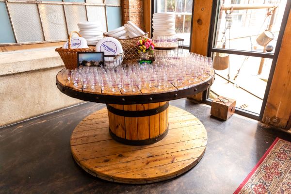 Wooden table with champagne glasses and wedding party gifts.