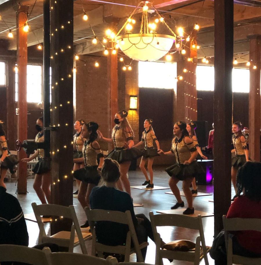 Young girls giving dance performance in front of parents in the Event Hall.