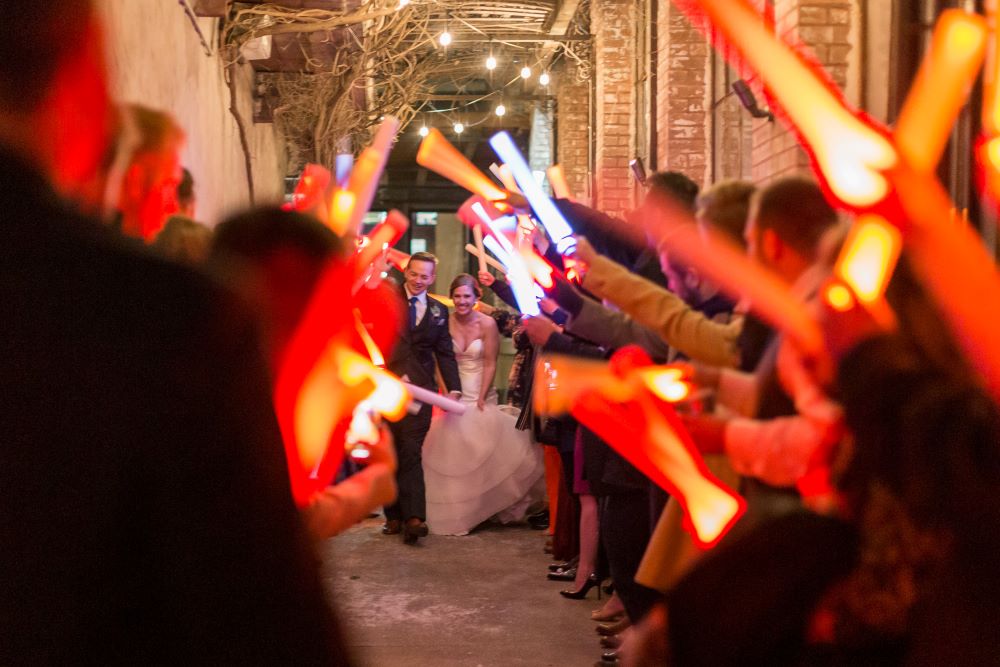 Guests holding up LED sticks during wedding couple's send-off.
