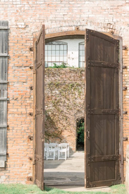 Tall wooden doors leading into the outdoor wedding ceremony area.