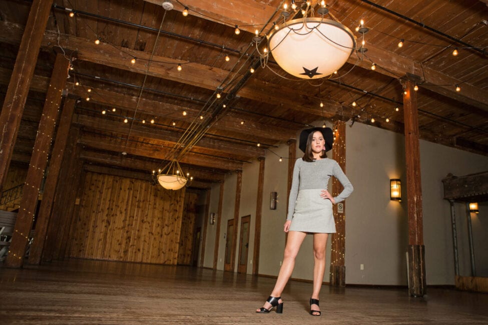 Girl standing with hand on hip in beautiful industrial event space.