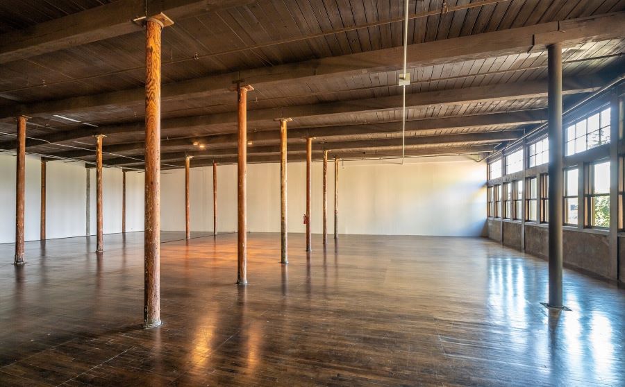 Empty office space with original industrial 1900s beams.