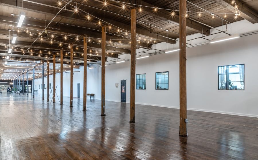 Renovated Atrium at The McKinney Cotton Mill with original industrial 1900s beams