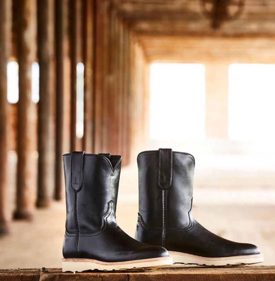 Black cowboy boots with warehouse background.